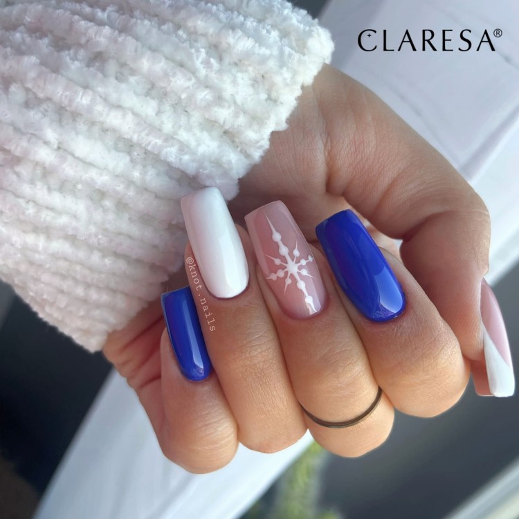 Claresa lakier hybrydowy "Neon 13". Stylizacja manicure wykonana z użyciem lakieru hybrydowego Claresa. Długie paznokcie biało, niebieskie + śnieżynka. Biały, sweterkowy rękaw.