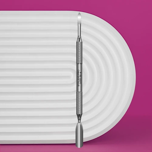 Staleks kopytko do manicure expert 30/6 (popychacz szeroki, zaokrąglony/ czyścik paznokci). Produkt w centralnej części zdjęcia. Tło biało- fioletowe.