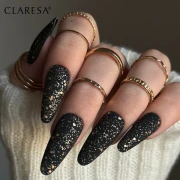 Lakier hybrydowy Claresa Black 900 5g. Dłoń i pomalowane paznokcie czarnym lakierem hybrydowym. Pierścionki. Długie paznokcie. Manicure.